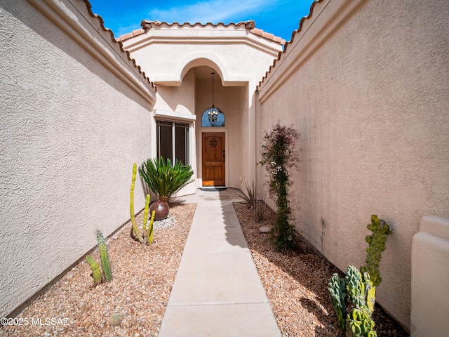 doorway to property with a tiled roof and stucco siding