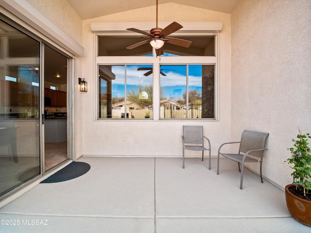 doorway to property with a ceiling fan and stucco siding