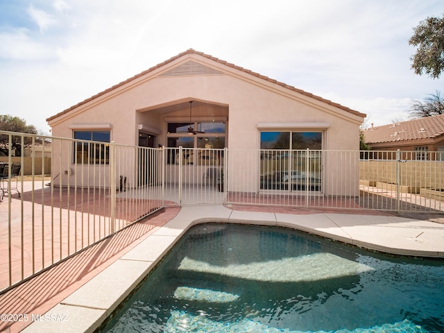 back of house featuring a patio, a tile roof, fence, and stucco siding