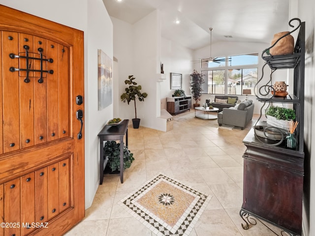 entrance foyer with light tile patterned floors, vaulted ceiling, and a ceiling fan