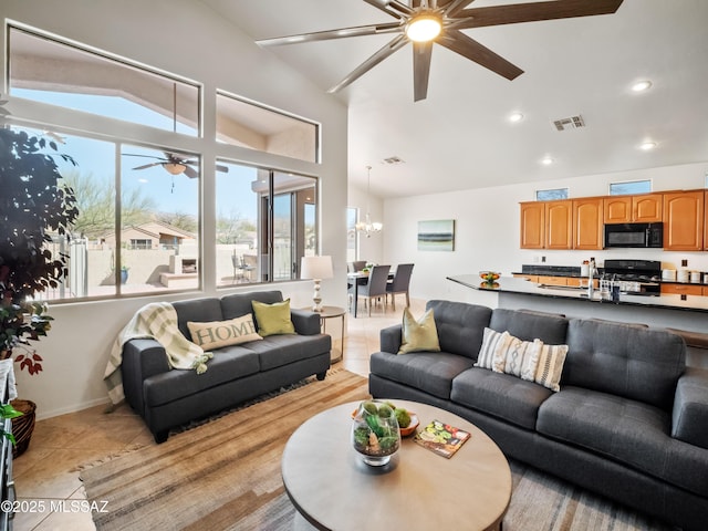 living area featuring light tile patterned floors, visible vents, and vaulted ceiling