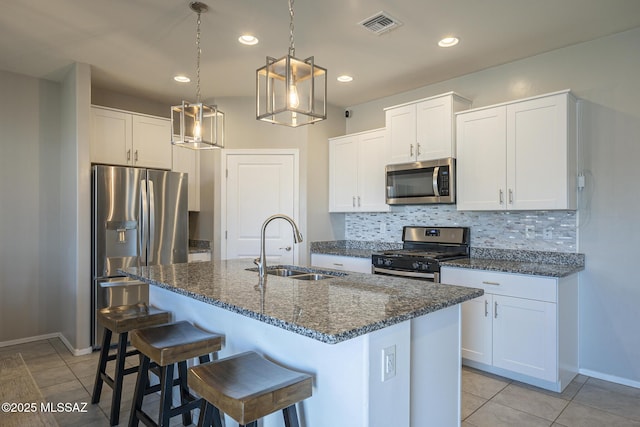 kitchen featuring appliances with stainless steel finishes, sink, a kitchen island with sink, and white cabinets