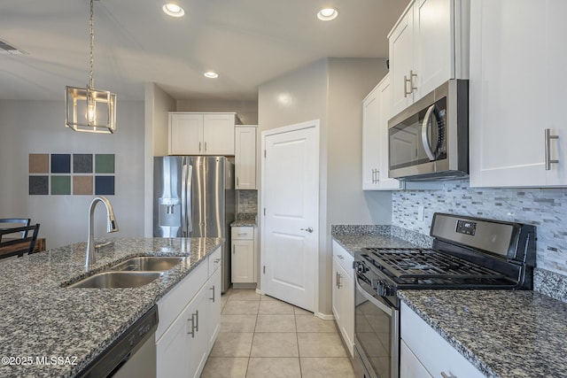 kitchen with sink, dark stone counters, white cabinets, and appliances with stainless steel finishes