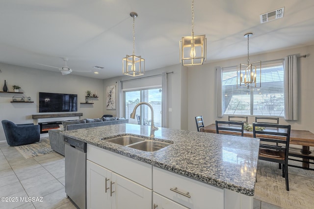 kitchen with hanging light fixtures, dishwasher, sink, and white cabinets