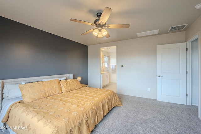 carpeted bedroom featuring ensuite bath and ceiling fan