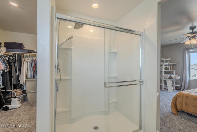 bathroom featuring a shower with door and ceiling fan