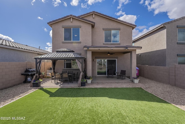 rear view of property with a gazebo, a lawn, ceiling fan, and a patio