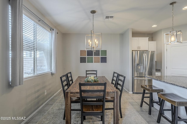 tiled dining area featuring a chandelier