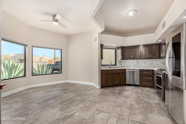 kitchen featuring ceiling fan, appliances with stainless steel finishes, tasteful backsplash, and dark brown cabinetry