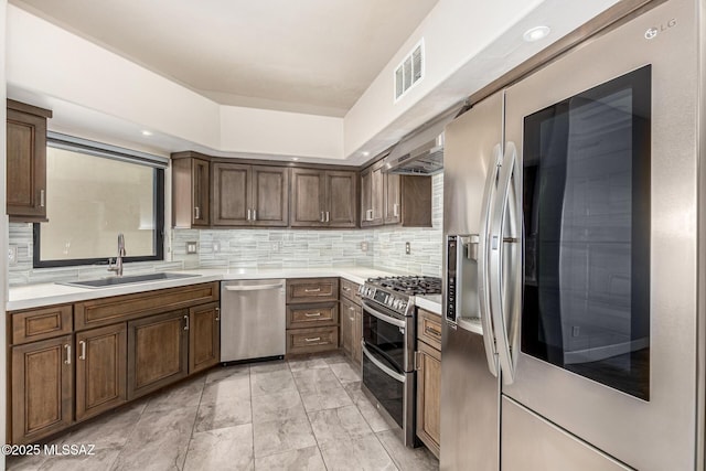 kitchen with decorative backsplash, sink, appliances with stainless steel finishes, and dark brown cabinets