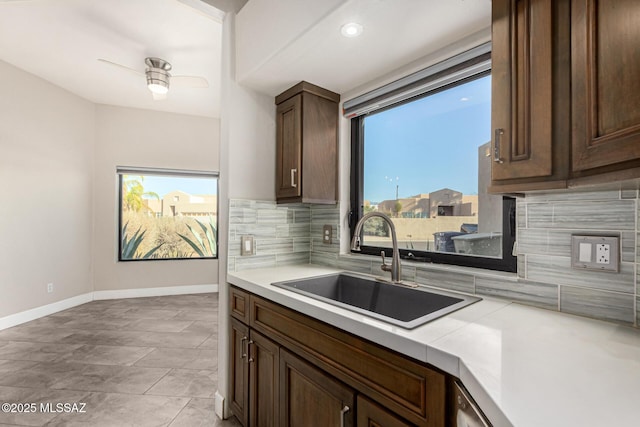 kitchen with ceiling fan, dark brown cabinets, tasteful backsplash, and sink