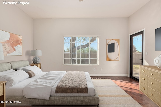 bedroom featuring access to exterior and dark wood-type flooring