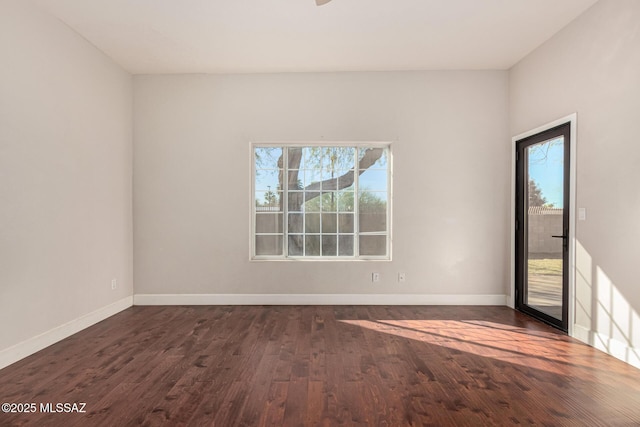 empty room featuring dark hardwood / wood-style flooring and plenty of natural light