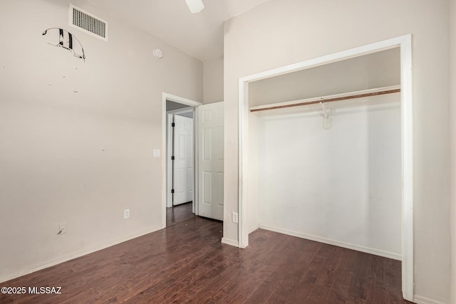 unfurnished bedroom featuring ceiling fan, dark wood-type flooring, and a closet