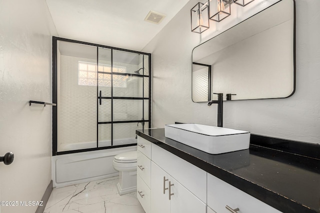 full bathroom with enclosed tub / shower combo, vanity, and toilet