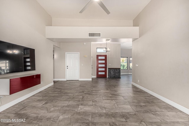 foyer entrance featuring ceiling fan with notable chandelier and a towering ceiling