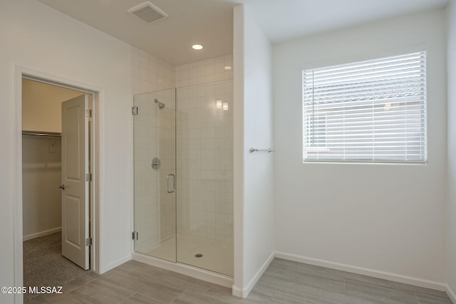 bathroom featuring a shower with door