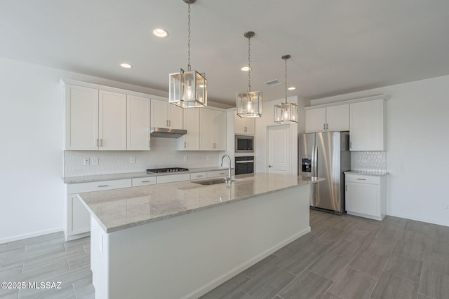 kitchen with white cabinetry, appliances with stainless steel finishes, a kitchen island with sink, and sink