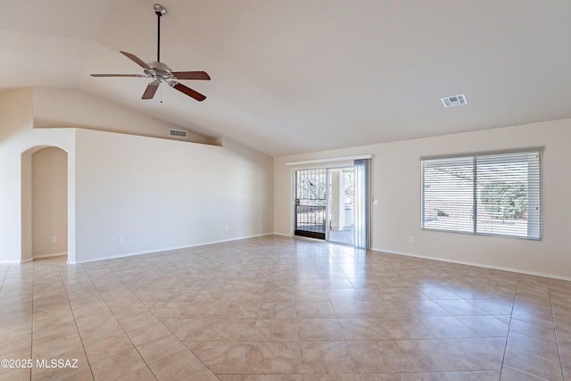 empty room featuring ceiling fan, light tile patterned floors, and vaulted ceiling