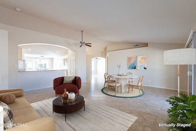 tiled living room with ceiling fan and vaulted ceiling