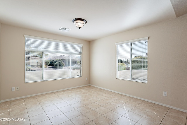 spare room featuring a healthy amount of sunlight and light tile patterned flooring