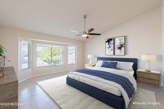 tiled bedroom with ceiling fan and lofted ceiling