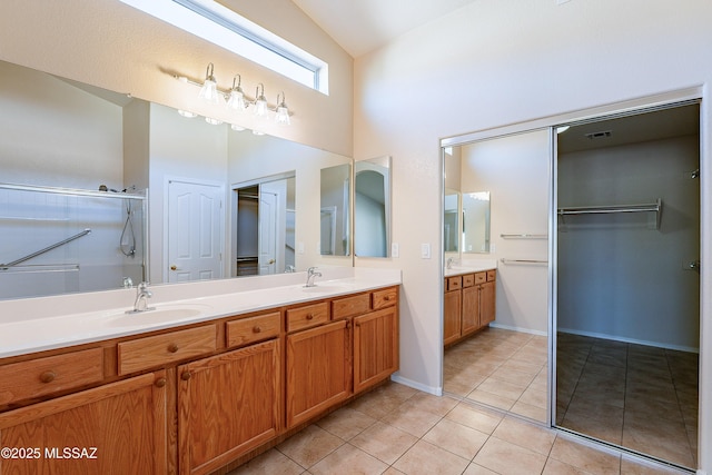 bathroom with tile patterned floors, an enclosed shower, vanity, and high vaulted ceiling