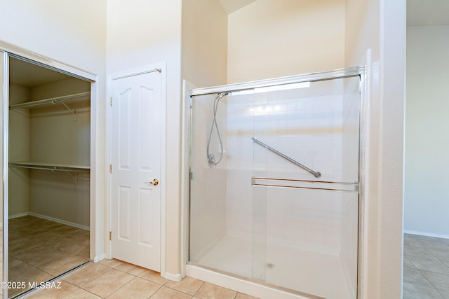 bathroom with a shower with shower door and tile patterned flooring