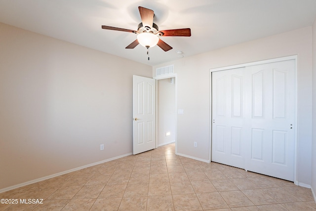 unfurnished bedroom with ceiling fan, a closet, and light tile patterned flooring