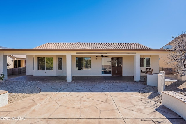 back of house with ceiling fan and a patio