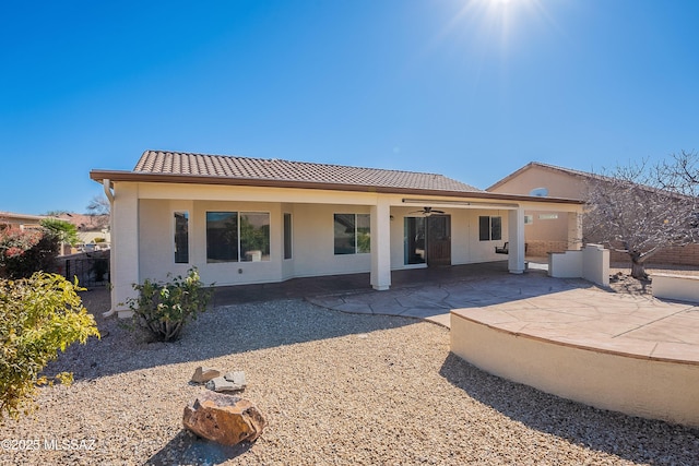 back of property with ceiling fan and a patio area