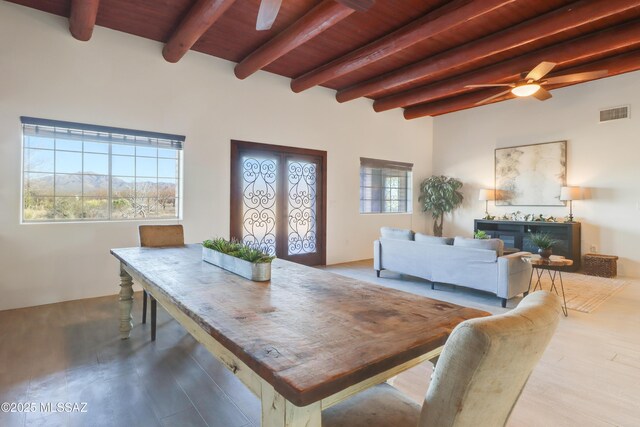 dining room featuring beam ceiling, wood-type flooring, french doors, and wooden ceiling