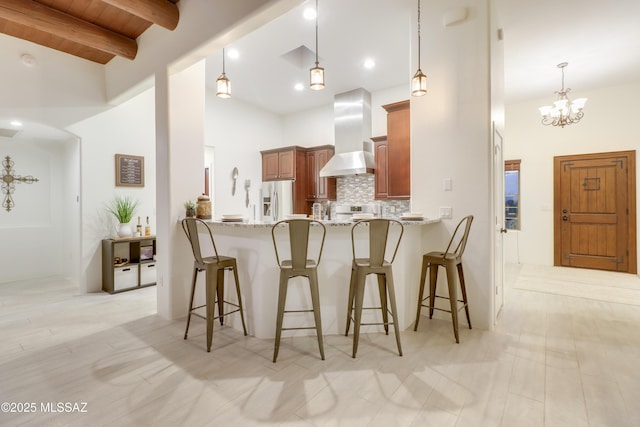 kitchen featuring refrigerator with ice dispenser, wall chimney range hood, beamed ceiling, kitchen peninsula, and wooden ceiling