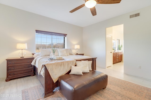 bedroom featuring ceiling fan, light wood-type flooring, and ensuite bathroom