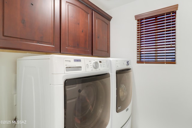 laundry room featuring cabinets and washer and clothes dryer