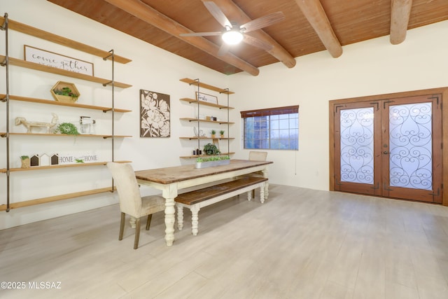 dining area featuring french doors, light wood-type flooring, ceiling fan, wooden ceiling, and beam ceiling