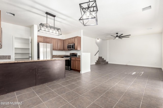 kitchen featuring hanging light fixtures, ceiling fan, appliances with stainless steel finishes, and dark tile patterned floors