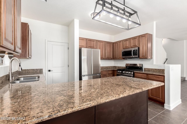 kitchen featuring light stone countertops, sink, hanging light fixtures, and stainless steel appliances