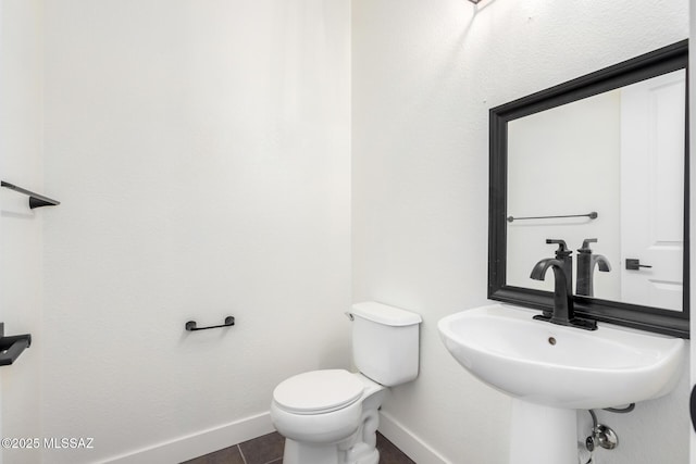 bathroom with sink, toilet, and tile patterned flooring