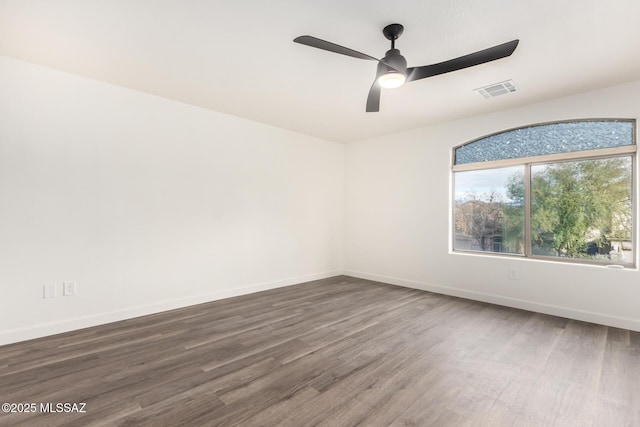 spare room featuring ceiling fan and dark wood-type flooring