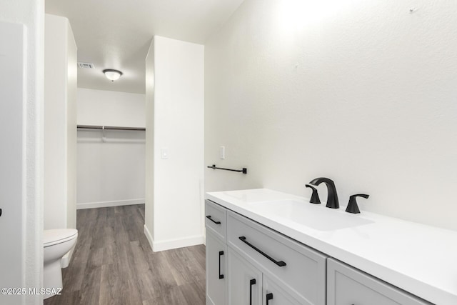 bathroom featuring toilet, vanity, and wood-type flooring