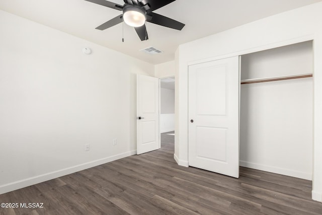 unfurnished bedroom with ceiling fan, a closet, and dark wood-type flooring