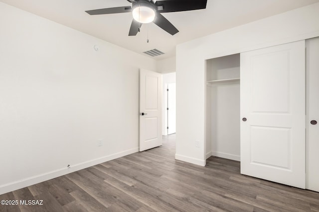 unfurnished bedroom featuring ceiling fan, wood-type flooring, and a closet