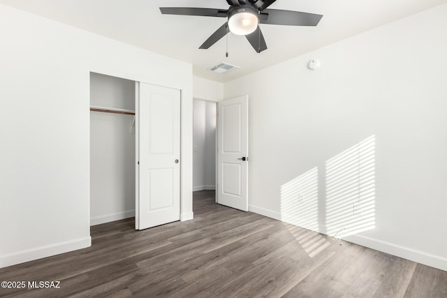 unfurnished bedroom with ceiling fan, dark hardwood / wood-style floors, and a closet