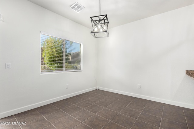 tiled empty room with a notable chandelier