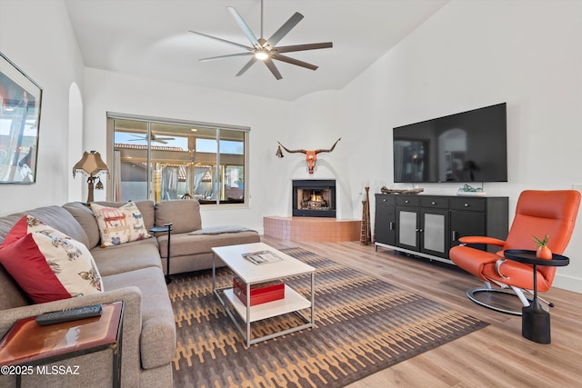 living room featuring vaulted ceiling, ceiling fan, and hardwood / wood-style floors