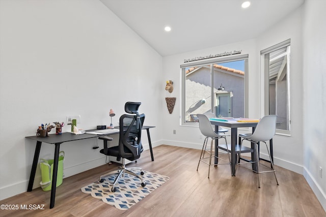 home office with vaulted ceiling and light hardwood / wood-style floors