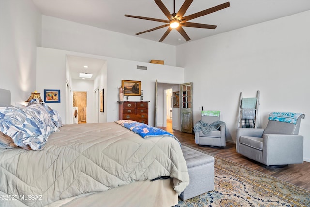 bedroom with dark wood-type flooring, ceiling fan, and ensuite bathroom