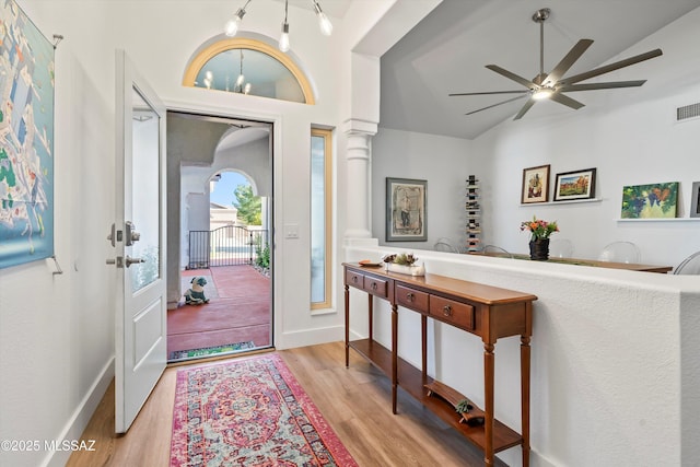 entrance foyer featuring lofted ceiling, decorative columns, ceiling fan, and light wood-type flooring