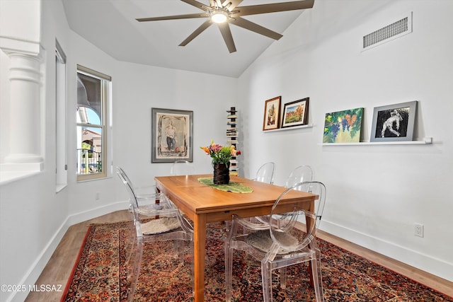 dining room featuring hardwood / wood-style floors, vaulted ceiling, and ceiling fan